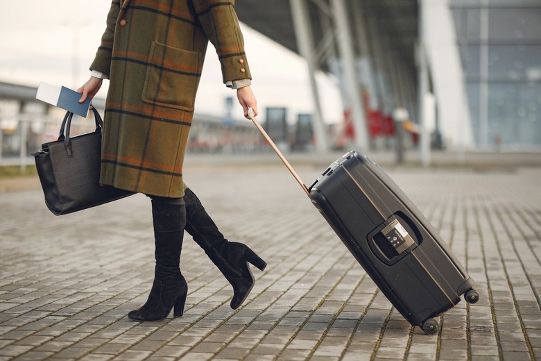 Stylish woman with a suitcase and bag