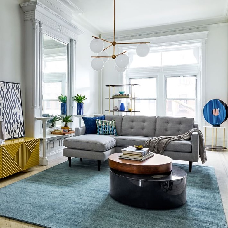 living room space with blue rug and gray couch