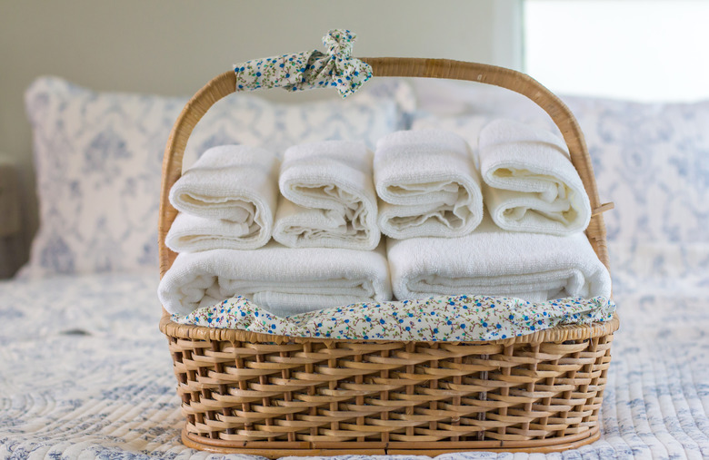 Close-Up Of Towels In Wicker Basket On Bed At Home