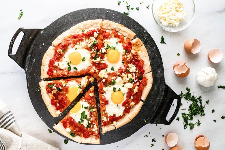 Shakshuka pizza on a black cast iron pizza pan