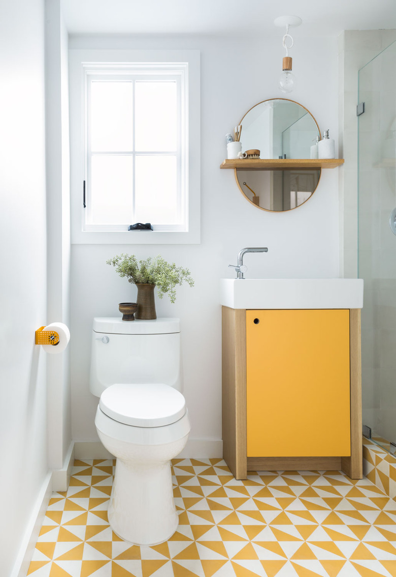 yellow patterned tiling and yellow fixtures in white bathroom