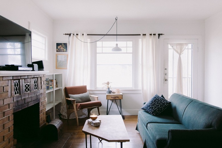 vintage fireplace in an eclectic living room with white walls and blue couch