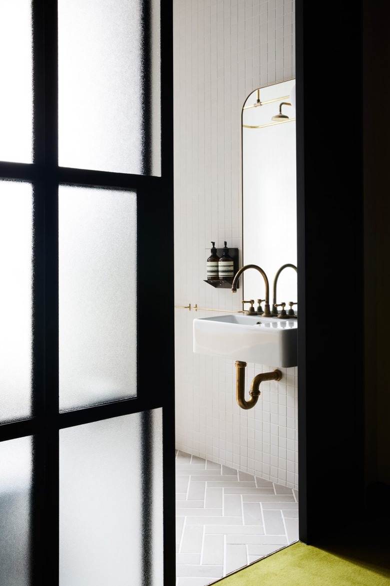 cement wall-mounted bathroom sink with gold gooseneck faucet