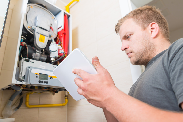 Technician repairing Gas Furnace using digital tablet