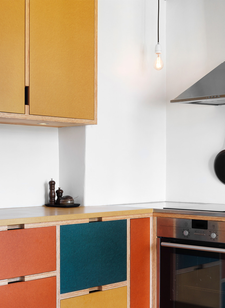 yellow kitchen cabinet idea with green and orange fronts and hanging pendant light