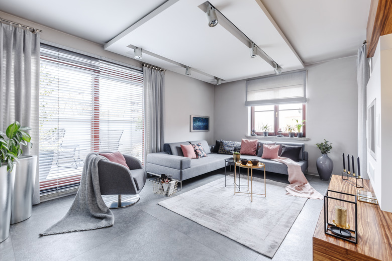 Bright gray living room with a variety of window treatments