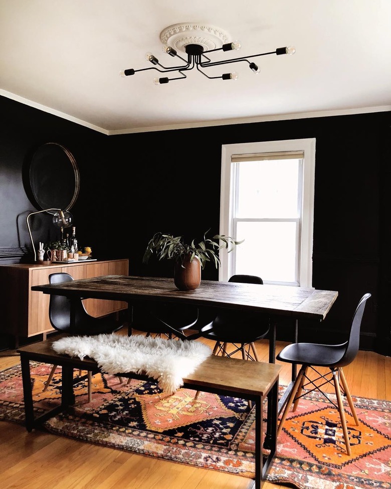 Black dining room with orange kilim rug