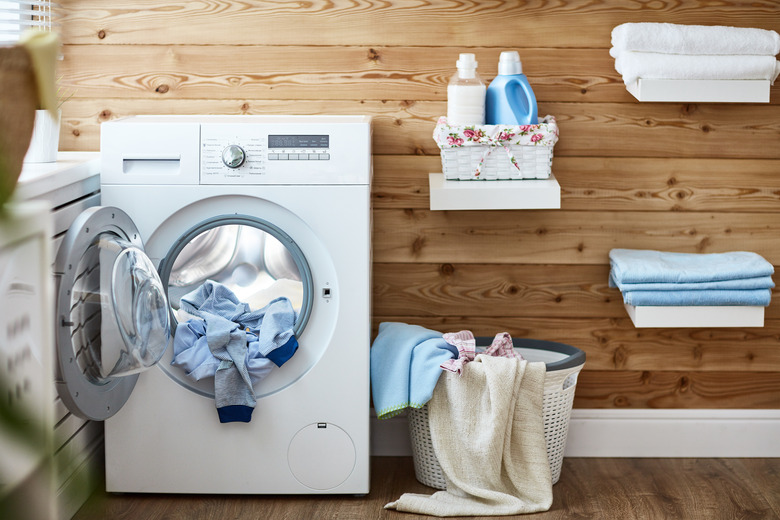 Interior of real laundry room with washing machine at window at home