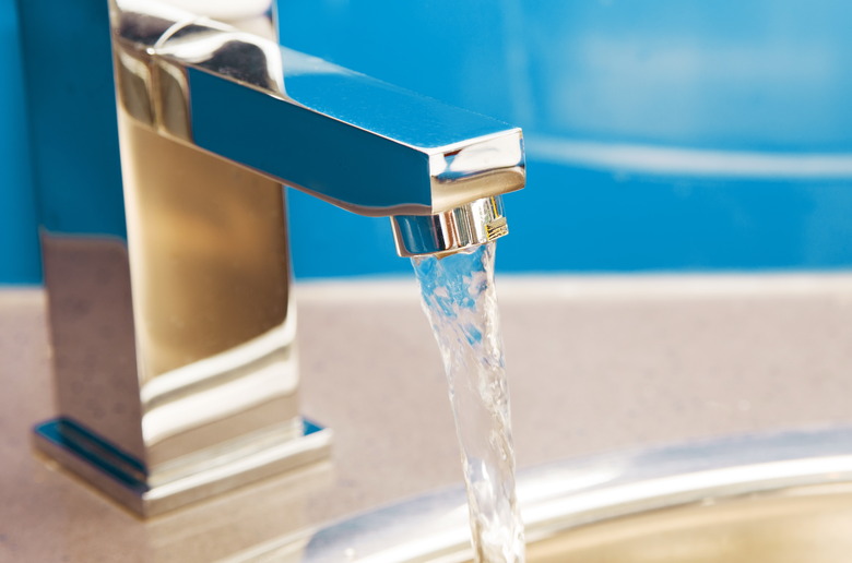 Closeup of water running from shiny, new faucet.