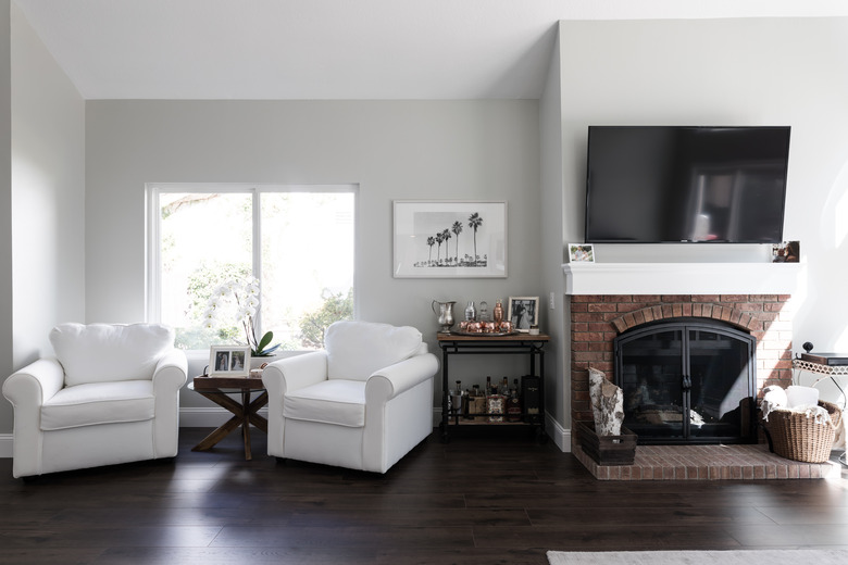 living room with light grey walls, light furniture, and dark floors