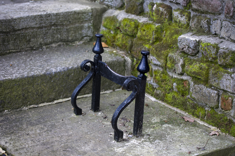 An antique black boot scraper affixed to the stone beneath a home