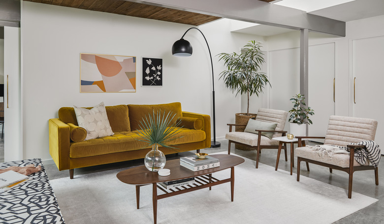 living room space with burnt orange couch and two chairs