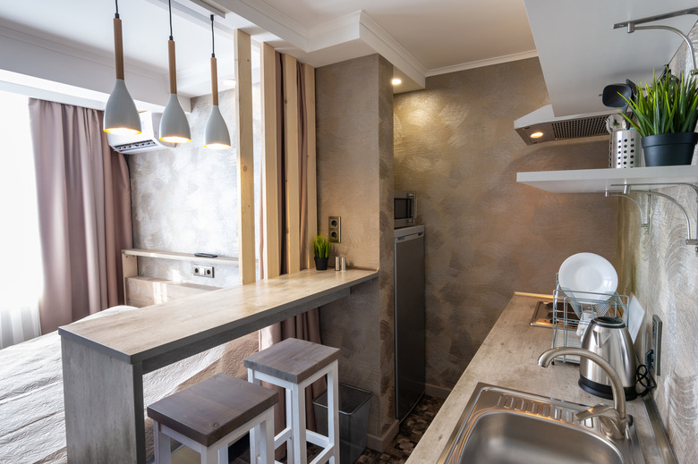 View of the kitchen and bar in a small hotel room - studio