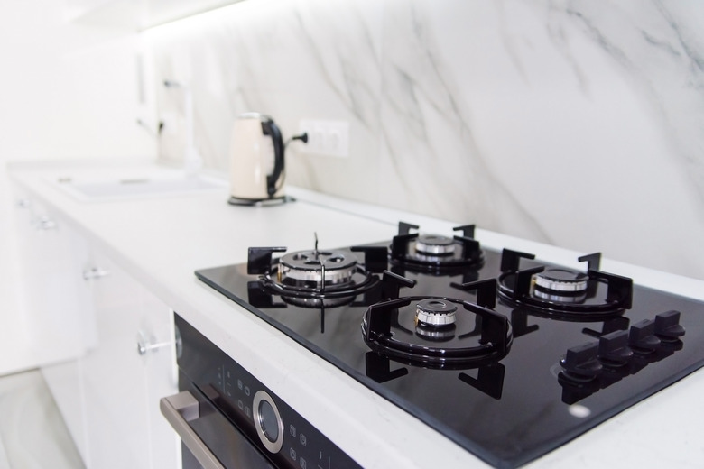 Modern high-tech black gas stove with sensor panel in the bright interior of the kitchen