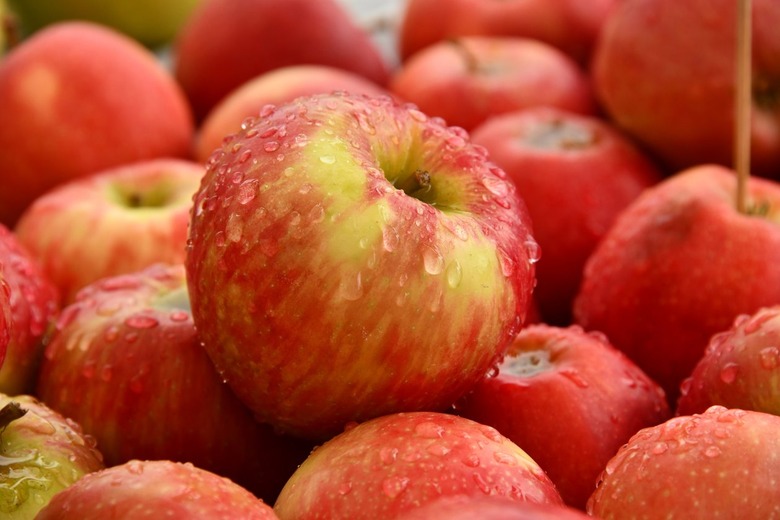 A pile of red apples that are covered in droplets of water.