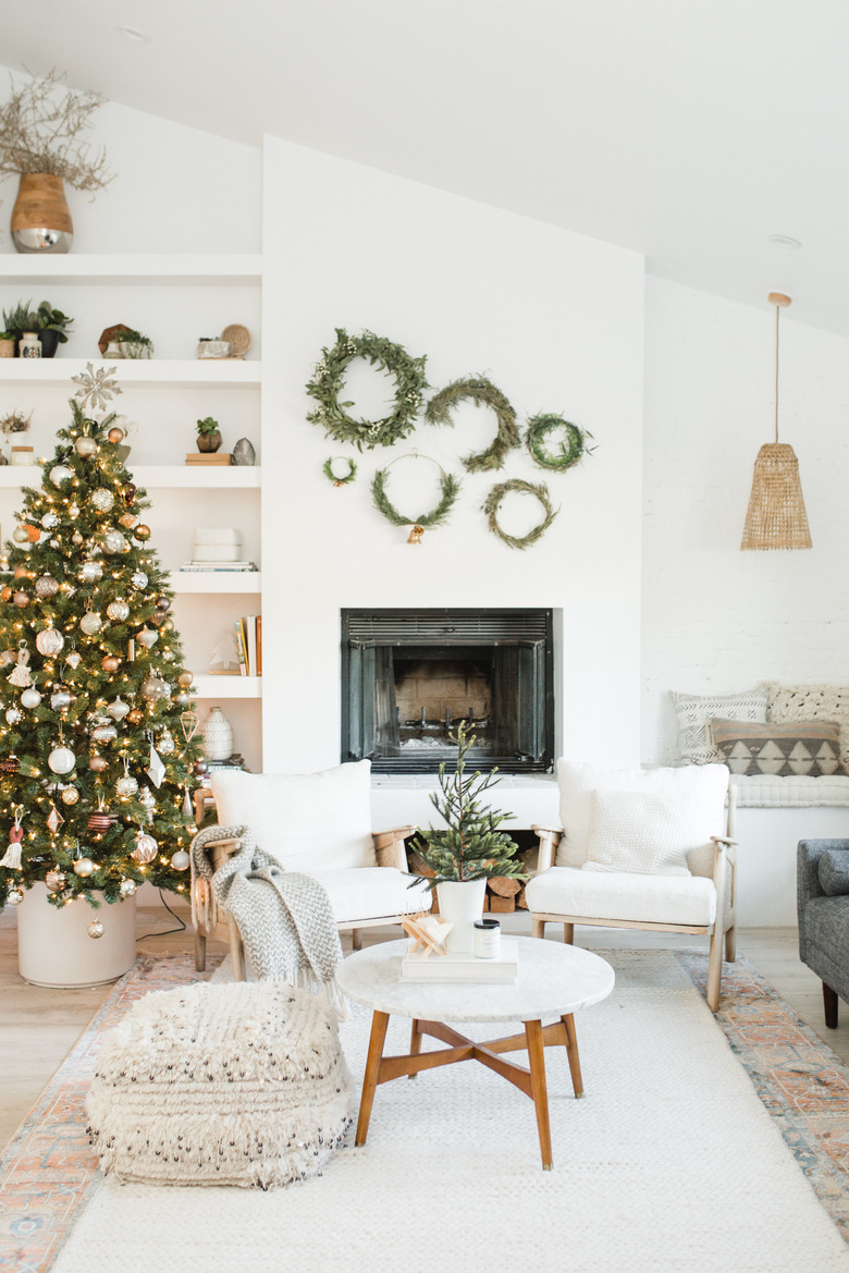 white christmas tree decorations in living room with fireplace and multiple wreaths