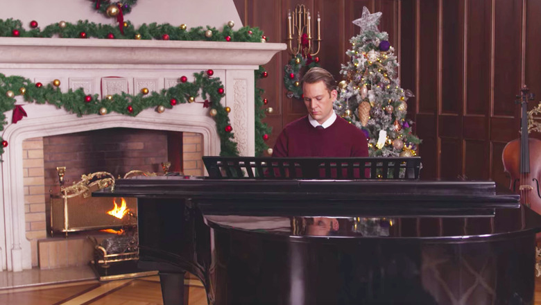 man sitting in front of piano in holiday decorated room