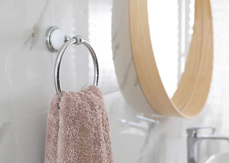 Holder with clean towel on light wall