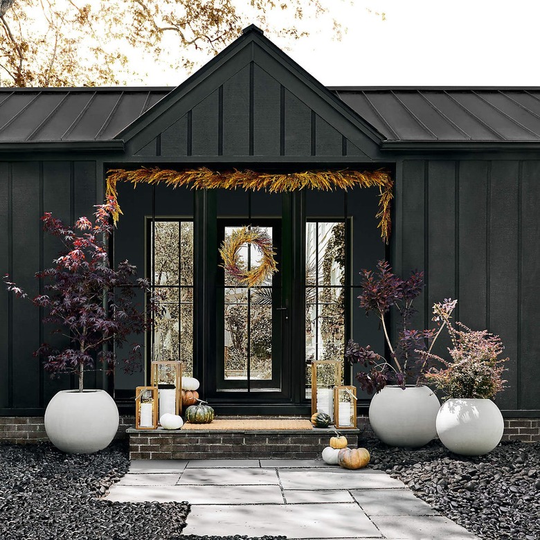 black home with wheat garland hung above the threshold