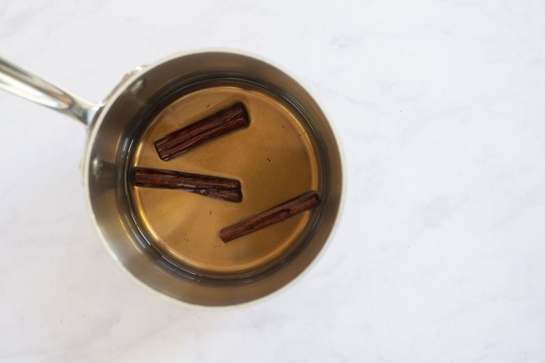 cinnamon sticks in liquid in pan