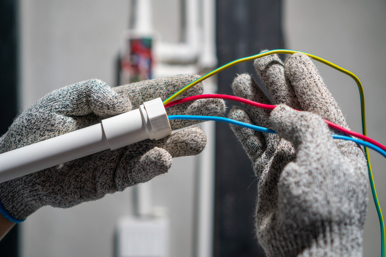 Electrician Pulling Wire Into PVC Conduit