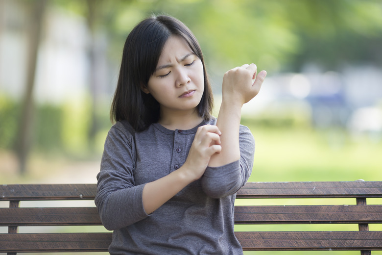 Woman scratching her hand.