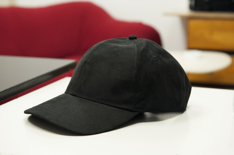 Black hat with visor on a white table.