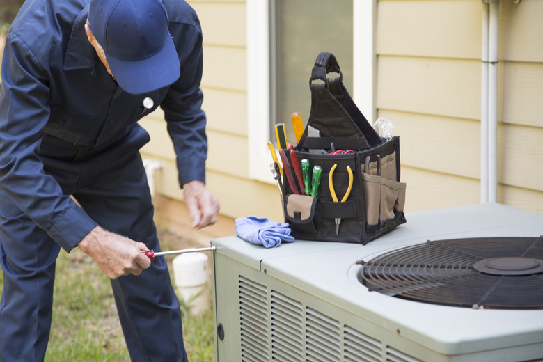 Technician servicing outside A/C unit.