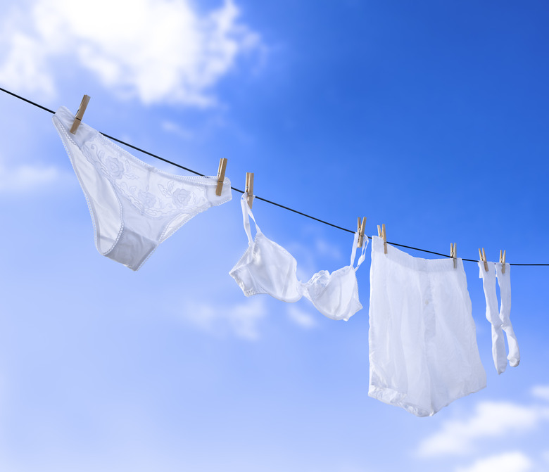 White underwear hanging under clear blue sky.