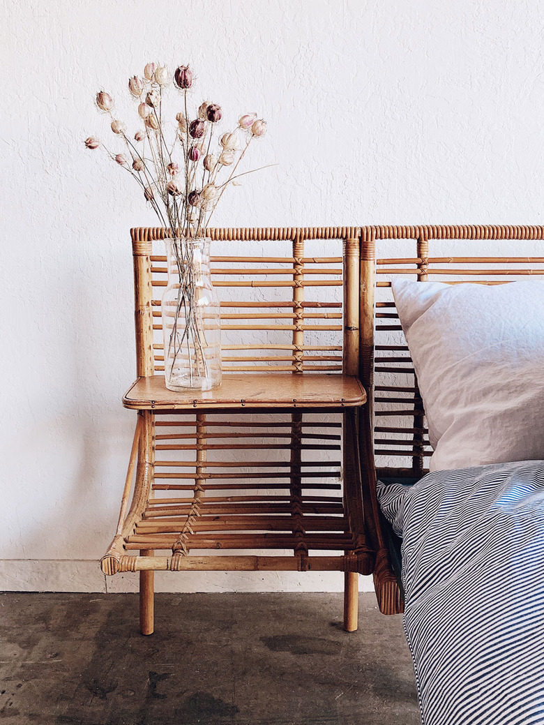 vintage bamboo daybed with striped duvet and vase of flowers