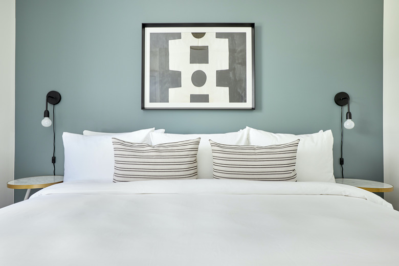 White bed against sage green wall