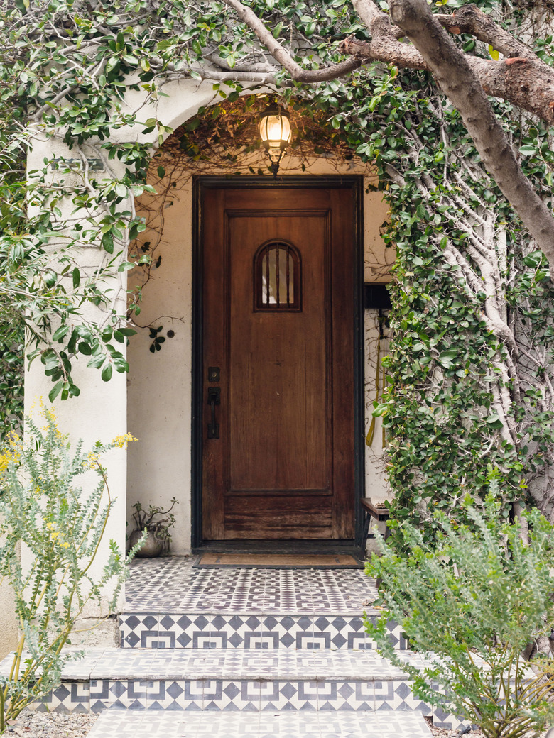 Exterior entryway with painted tile steps and wooden exterior door