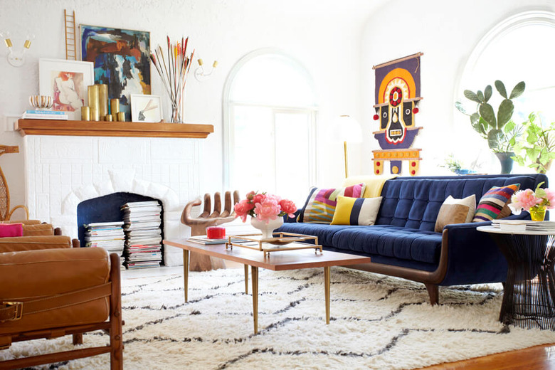 Colorful living room with blue sofa and white brick fireplace