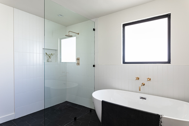 bathroom with shower with glass wall, and stand-alone bathtub