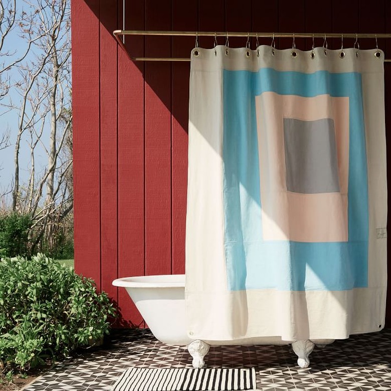 eco-friendly shower curtain with modern blue design in an outdoor bathroom against red wall