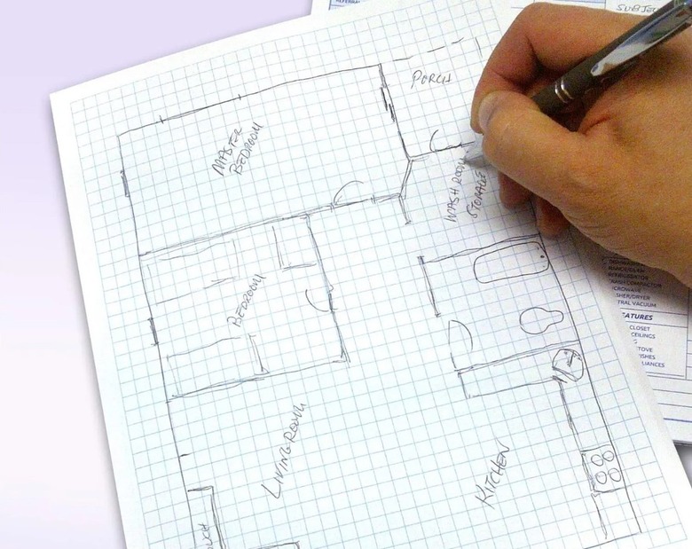 Sketching a house plan on graph paper.