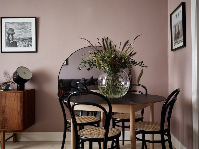 mauve dining area wirh black accents via picture frames, dining chairs and lighting