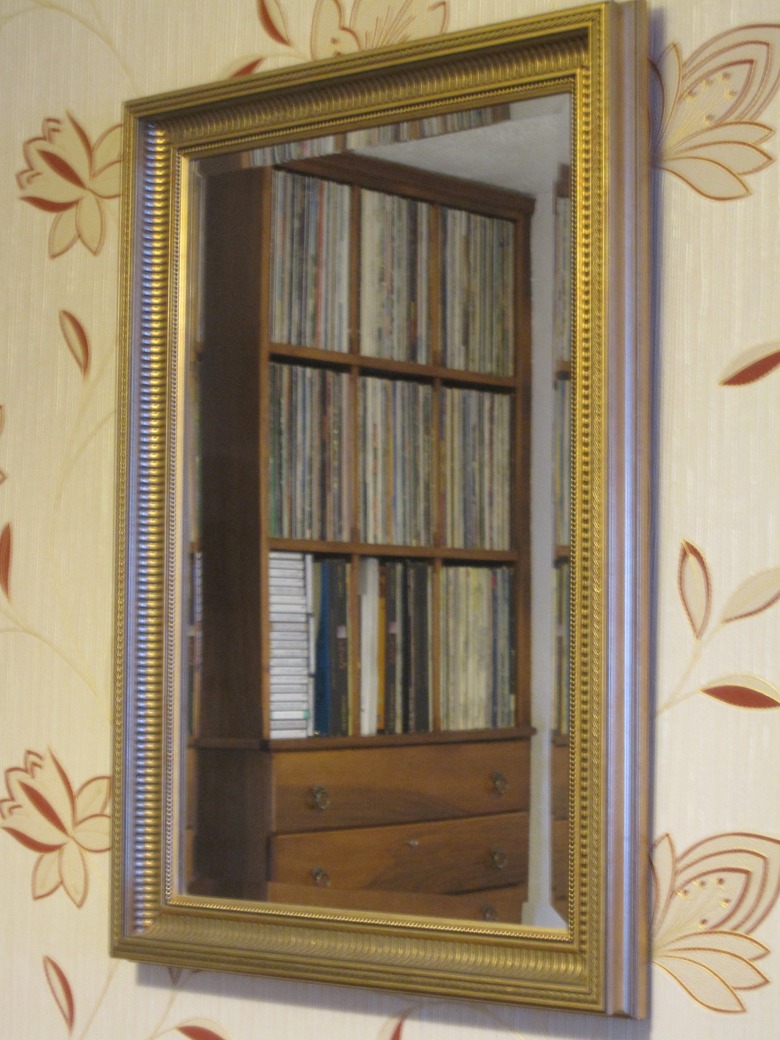 Mirror reflecting a record collection.