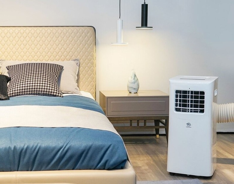 Portable air conditioner in blue, white, and beige bedroom