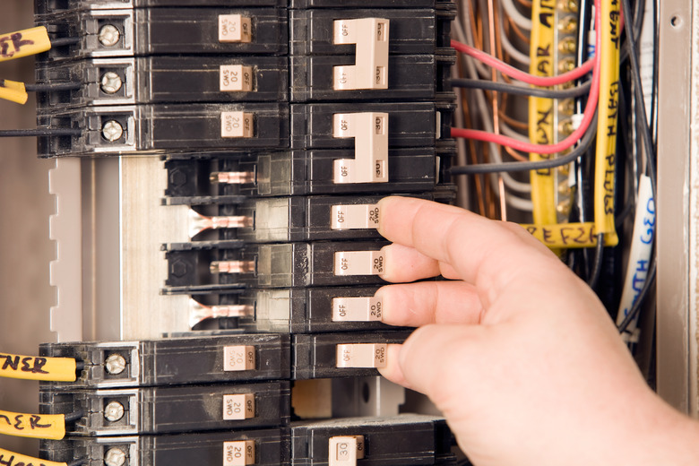 Electrician's Hand Turning On Circuit Breakers