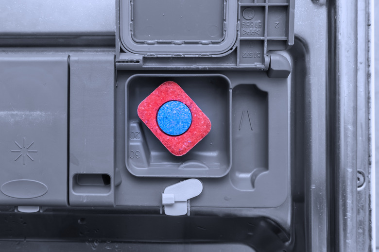 A tablet of a detergent for washing dishes in dishwashing machine container