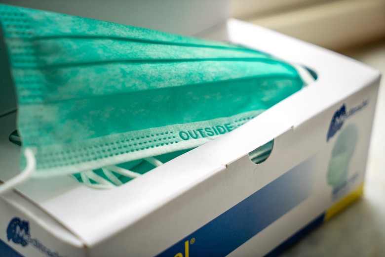 white box filled with teal disposable face masks