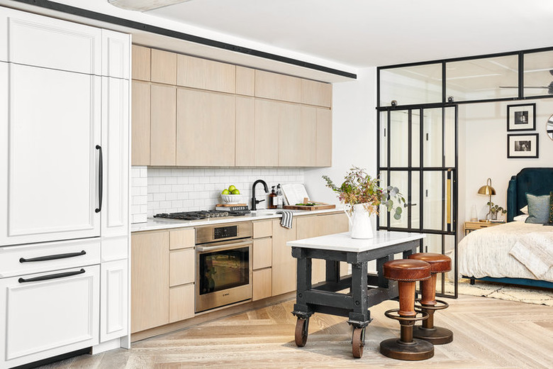 small industrial kitchen island with marble top on wheels in renovated aprtment