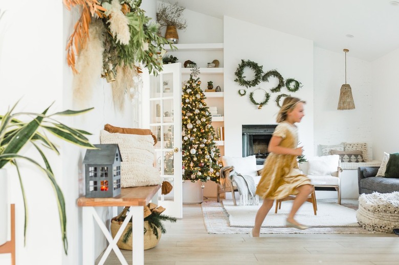 Young girl running through large living room with boho Christmas decor