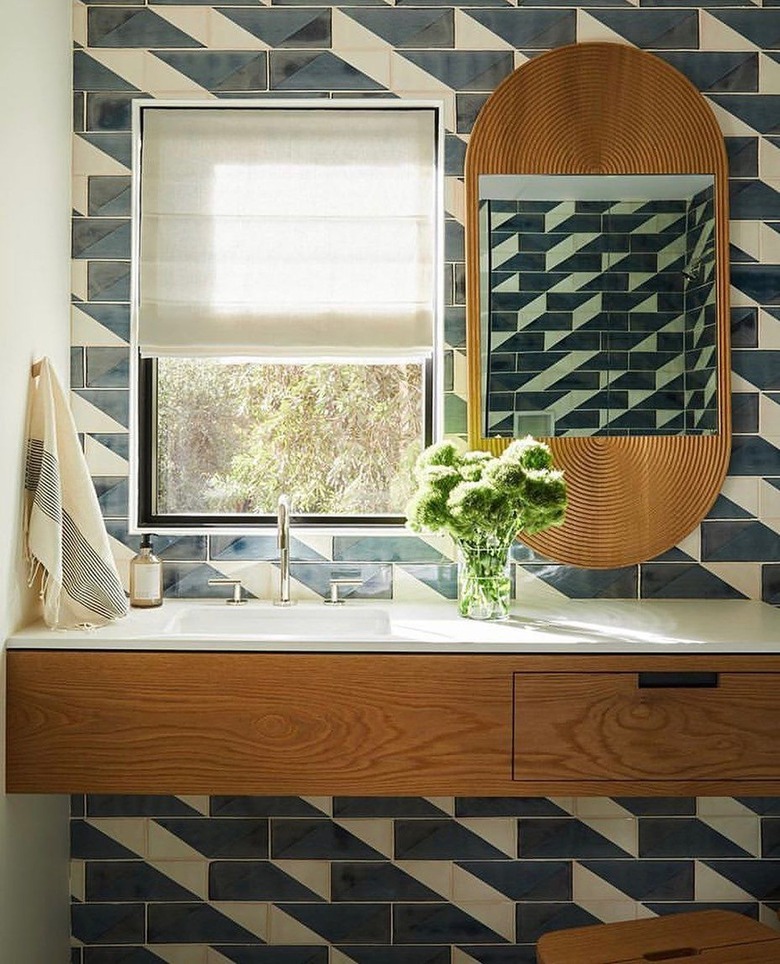 asymmetric backsplash tile in blue and white with wood vanity