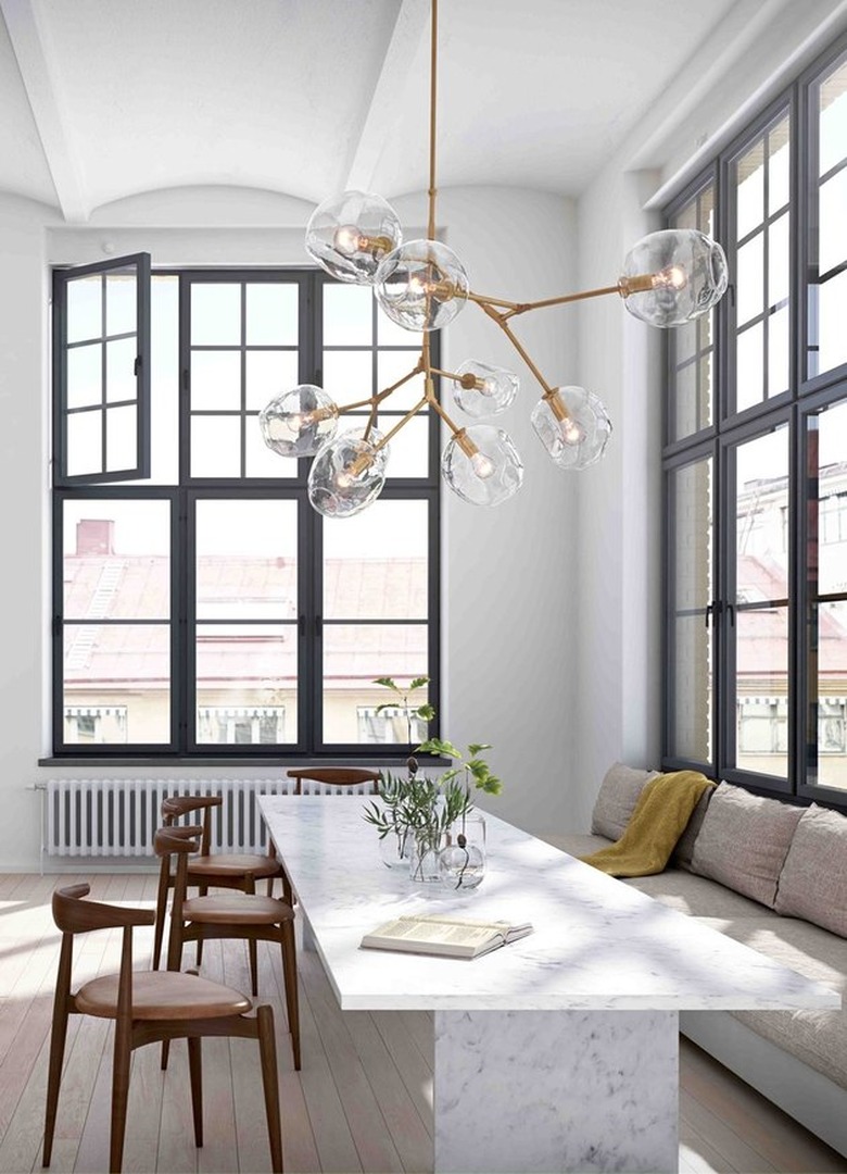 modern dining room with statement chandelier and black window frames