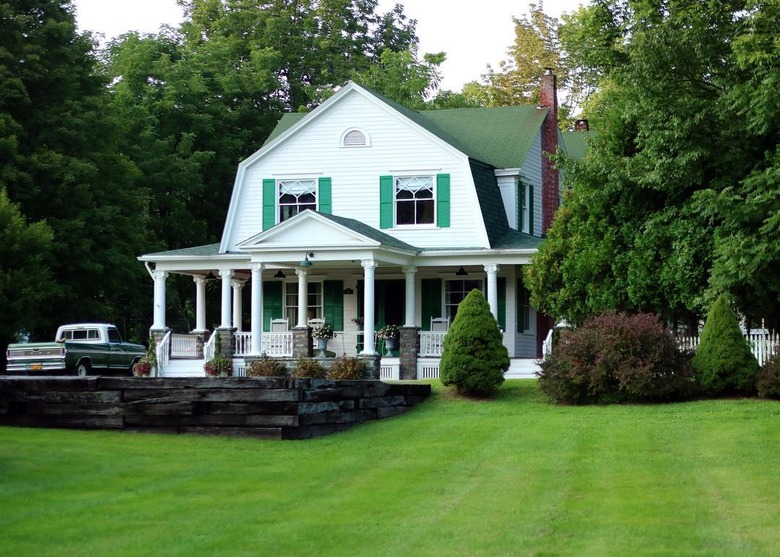 A barn home with green shutters and columns