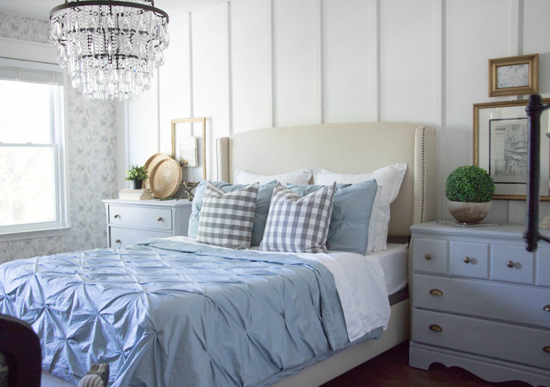 chandelier hanging above a bed in paneled bedroom