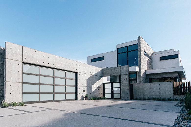 concrete house with glass and metal modern garage doors