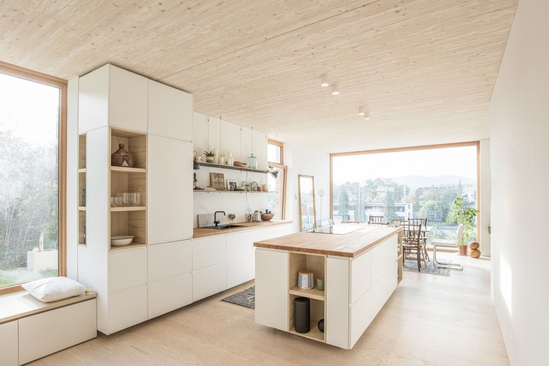 modern kitchen island with white cabinets and wood countertop